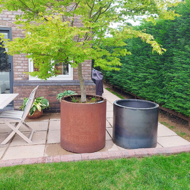 Shot of the planter with an edging lip next to another planter which has not rust as much